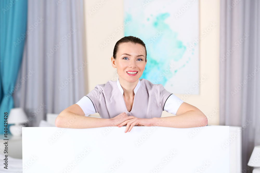 Beautiful chambermaid wearing uniform in room Beautiful chambermaid wearing uniform in room