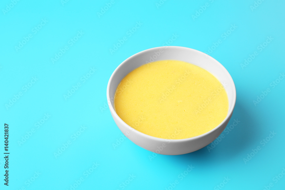 Bowl with tasty cheese sauce on color background Bowl with tasty cheese sauce on color background