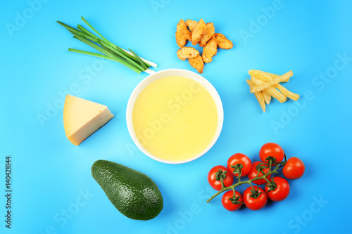 Fototapeta Naklejka Na Ścianę i Meble -  Bowl with tasty cheese sauce and different products on color background