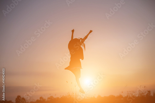 A cheerful woman jumps at the sun.