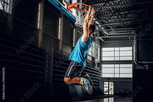  Black basketball player in action in a basketball court. © Fxquadro