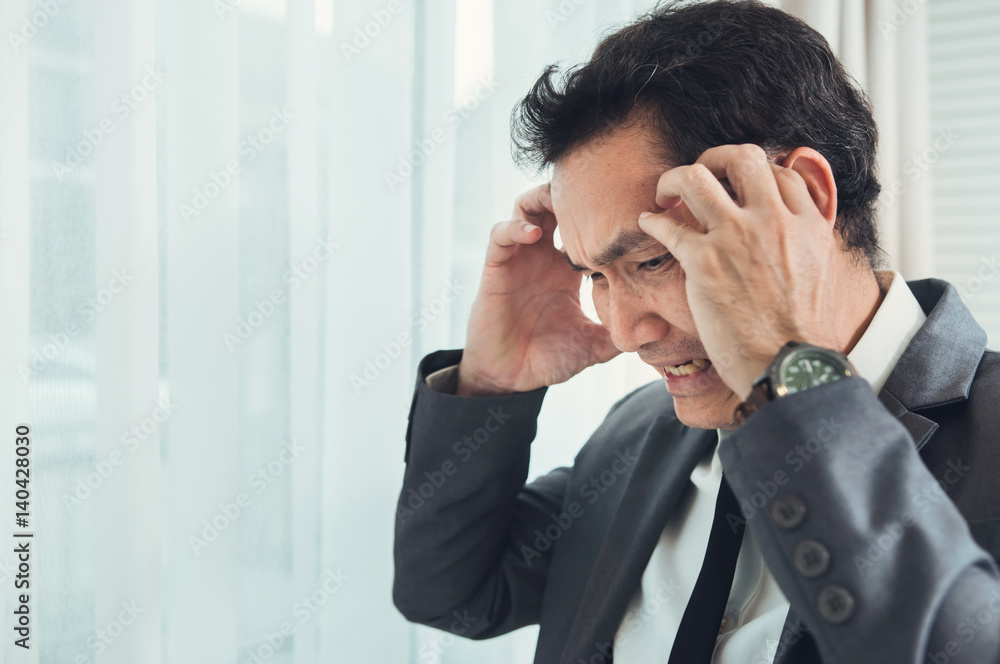 Asian businessman has headache from migraine from overworked. Illness, exhausted, disease, tired concept. Asian businessman has headache from migraine from overworked. Illness, exhausted, disease, tired concept.