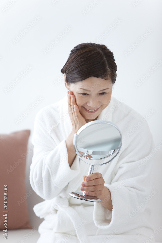 Middle-Aged Woman Wearing Bathrobe Using Mirror Middle-Aged Woman Wearing Bathrobe Using Mirror