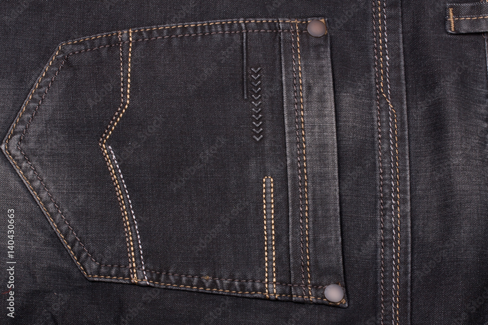 back pocket of dark jeans close up