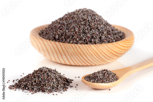 poppy seeds in a wooden bowl and spoon isolated on white background