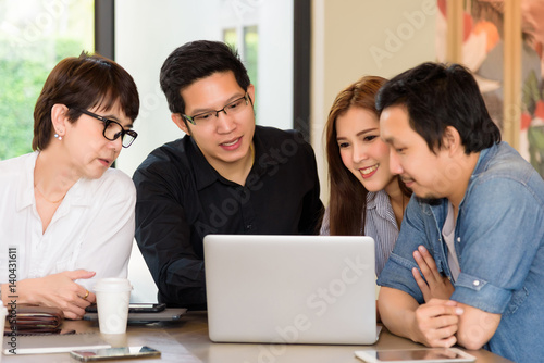 Asian Team group freelancer are brainstorming and meeting at coffee shop cafe. Feeling funny and happy.