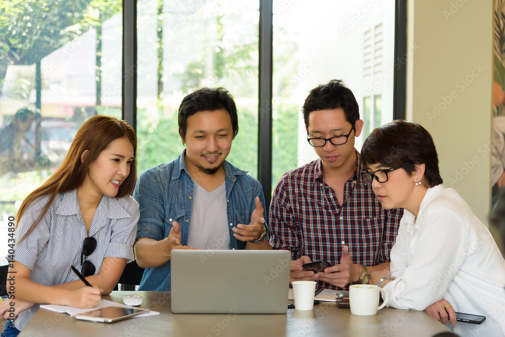 Asian handsome businessman in casual suit present project to team group freelancer in meeting at coffee shop cafe. Business and Technology concept. Asian handsome businessman in casual suit present project to team group freelancer in meeting at coffee shop cafe. Business and Technology concept.