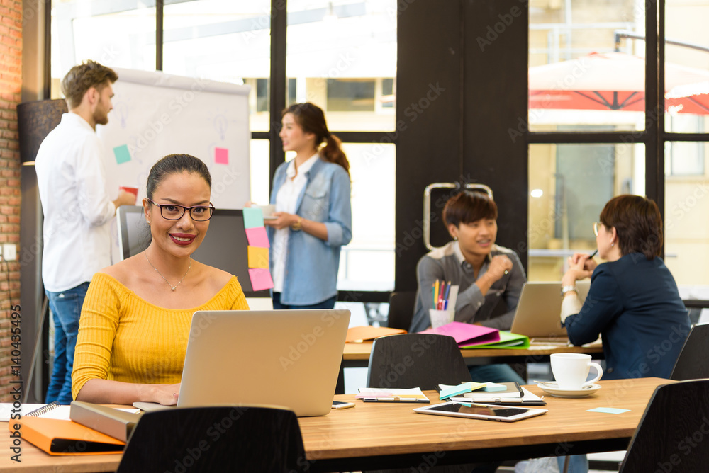 Asian charming beautiful business woman in modern office and blurred multi ethnic business person group in casual suit in background. Project and Business concept.