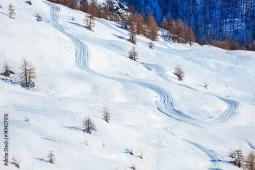 Skis or snowboarding traces on snow-covered slope