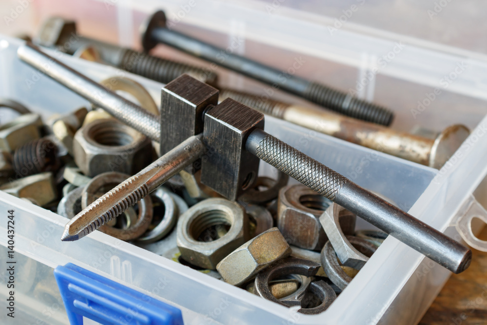 Fototapeta premium Machine tap with the old bolts and nuts in a storage box
