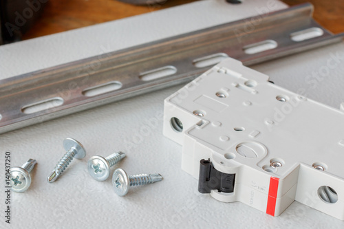 DIN rail, circuit breaker and the screws on the mounting plate