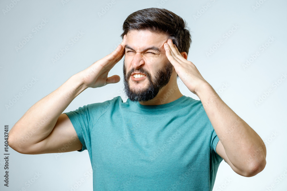 Depressed handsome bearded man touching having a headache Depressed handsome bearded man touching having a headache