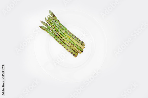 Grilled asparagus on glass plate, on a white background