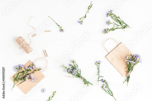 Flowers composition. Gifts and wildflowers on wooden white background. Flat lay, top view