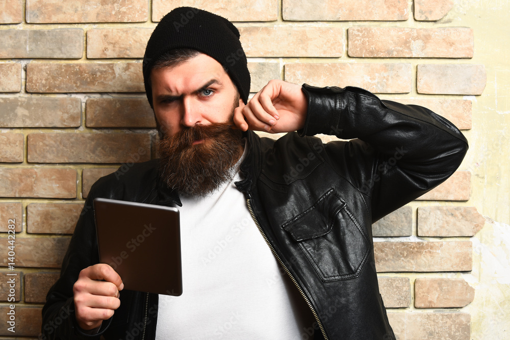 Bearded brutal caucasian hipster holding tablet