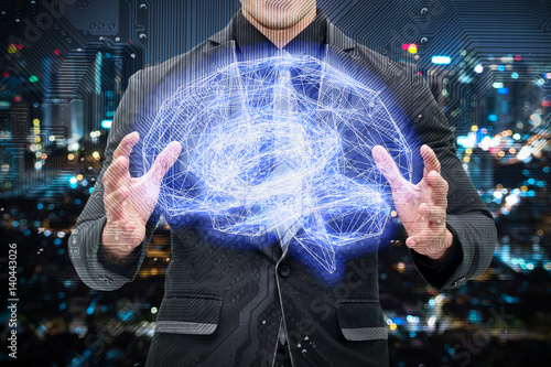 Machine learning , artificial intelligence , ai , deep learning and future concept. Man suit holding Wireframe Brain connect with circuit electronic graphic with bokeh city background photo