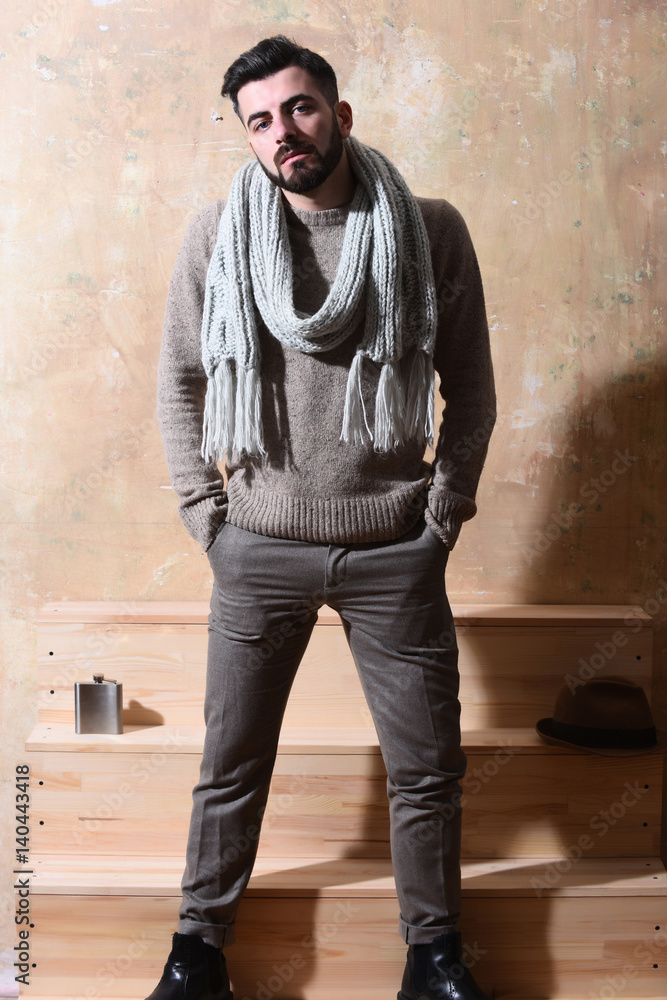 bearded man with serious face on background of wall