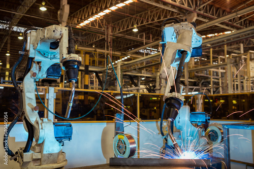 Team robots are welding assembly part in car factory