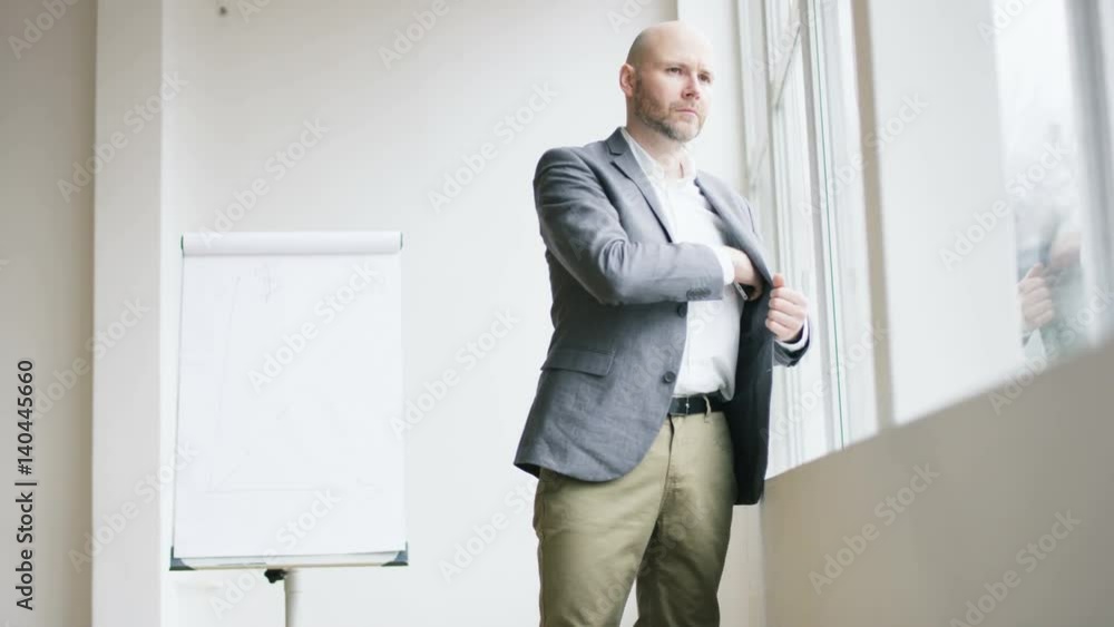 Bald Businessman Putting a Mobile Into His Jacket Bald Businessman Putting a Mobile Into His Jacket