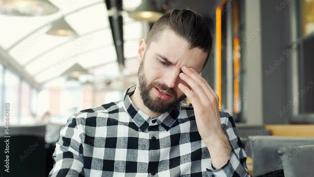 Man looks unhappy while having painful headache in the cafe
Man looks unhappy while having painful headache in the cafe