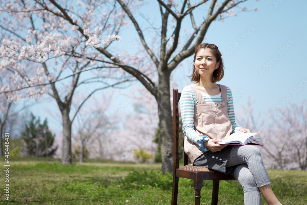 Young Woman sitting on chair reading a book Young Woman sitting on chair reading a book