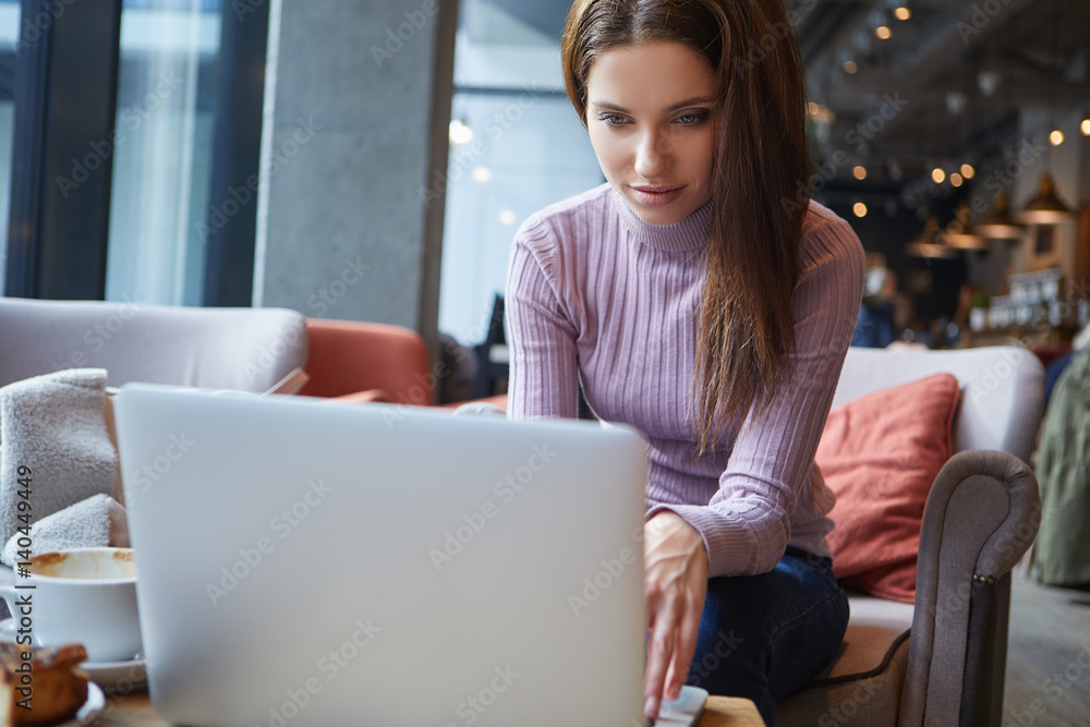 Beautiful brunette using laptop in cafe. Blogger work concept Beautiful brunette using laptop in cafe. Blogger work concept