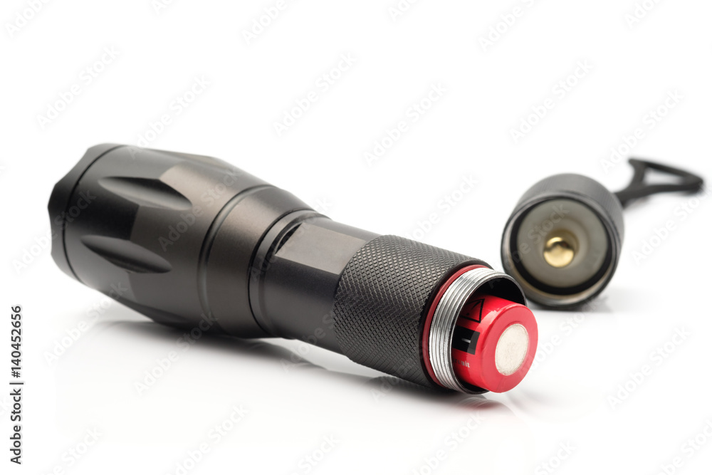 black flashlight opening the tail cap and have red alkaline battery inside on white background