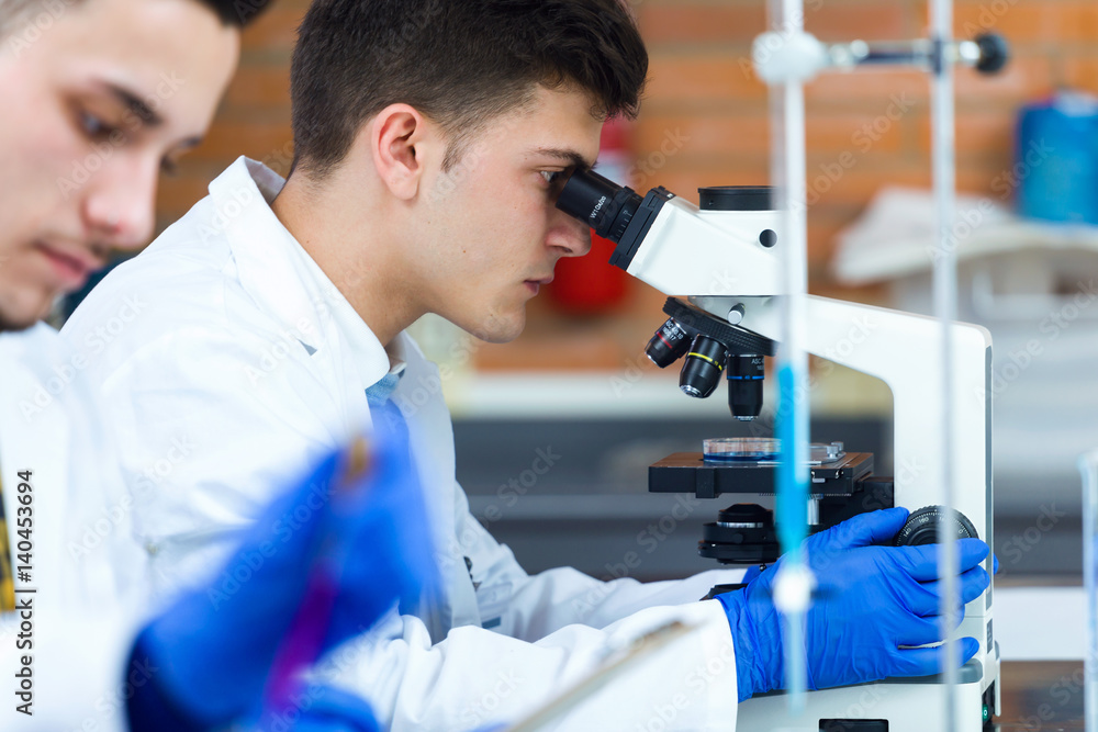 Young scientists carrying out an experiment in a laboratory. Young scientists carrying out an experiment in a laboratory.