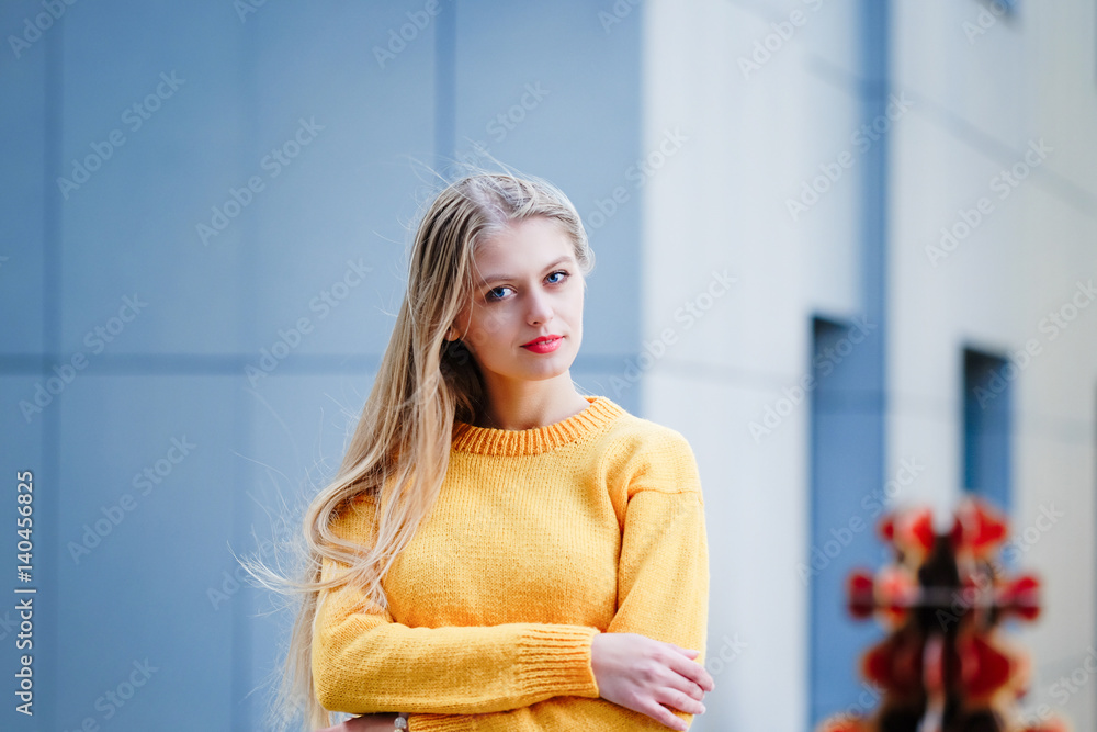 Fashionable long blond hair young woman in the city