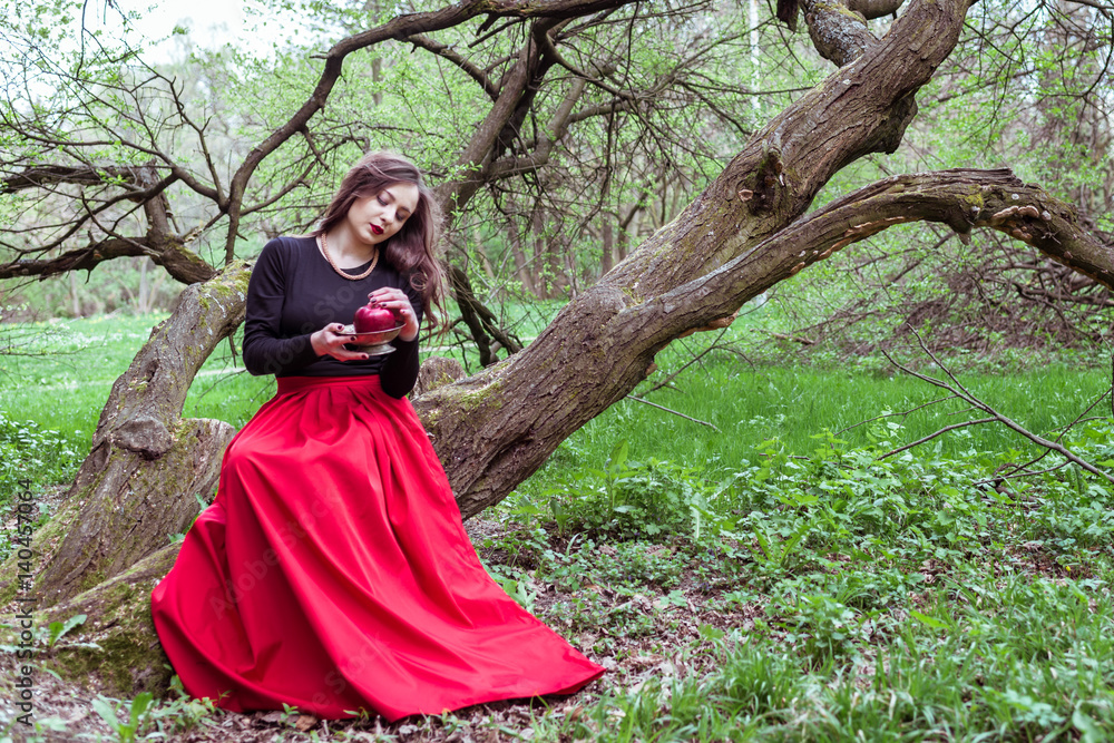 Fototapeta premium girl sitting on a tree trunk