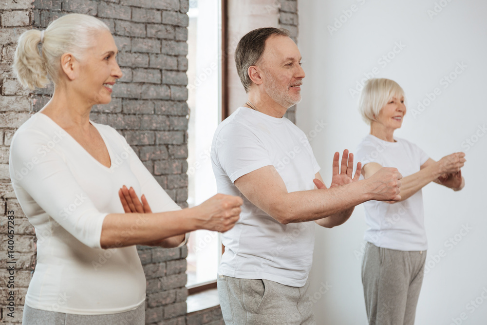 Fototapeta premium Three elderly people keeping hands in front of themselves