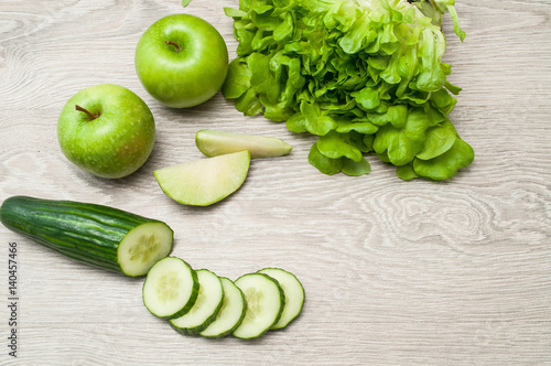 Green apples and vegetables on a wooden table, cooking. Dietary products. The concept of a healthy diet.