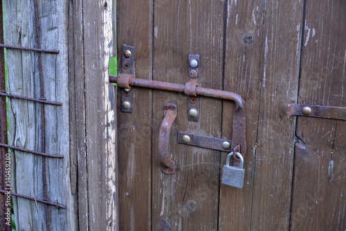 rusty iron bolt on a wooden door 