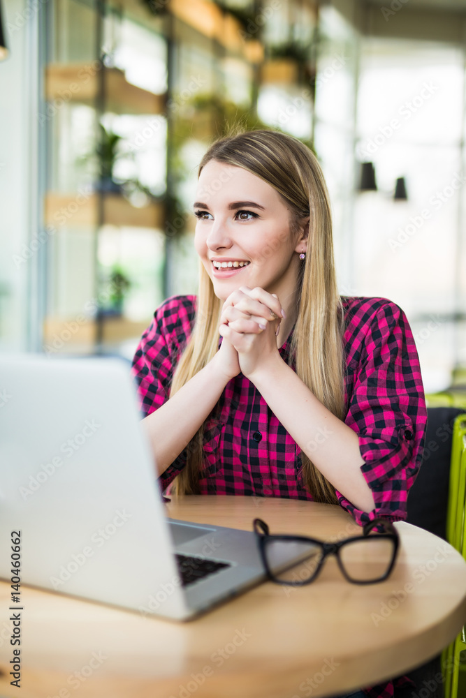 Portrait of a businesswoman sitting at the table in office and looking at camera Portrait of a businesswoman sitting at the table in office and looking at camera