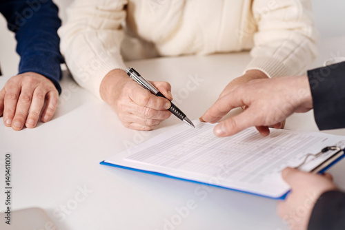 Senior couple signing important document at home