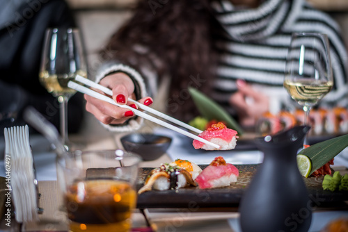 Hands eat sushi with chopsticks