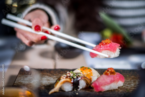 Hands eat sushi with chopsticks