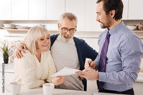 Positive aging couple owners meeting financial adviser at home