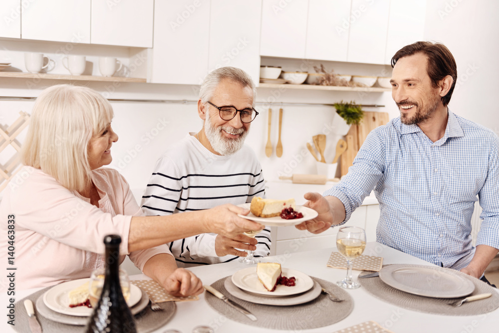 Smiling man enjoying family dinner at home Smiling man enjoying family dinner at home