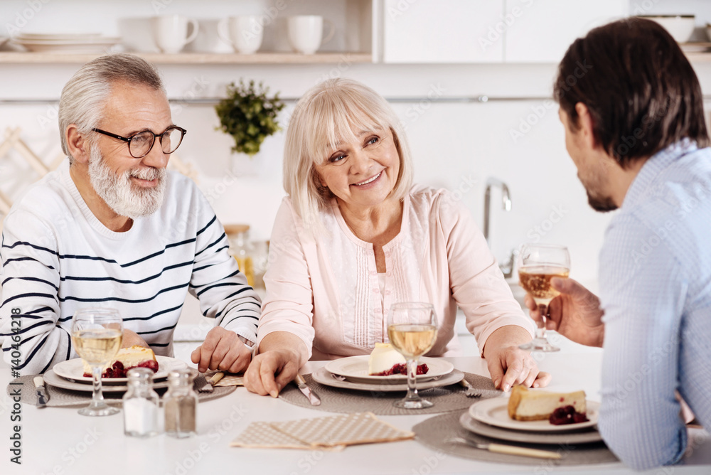 Cheerful family sitting at the dinner table in the kitchen