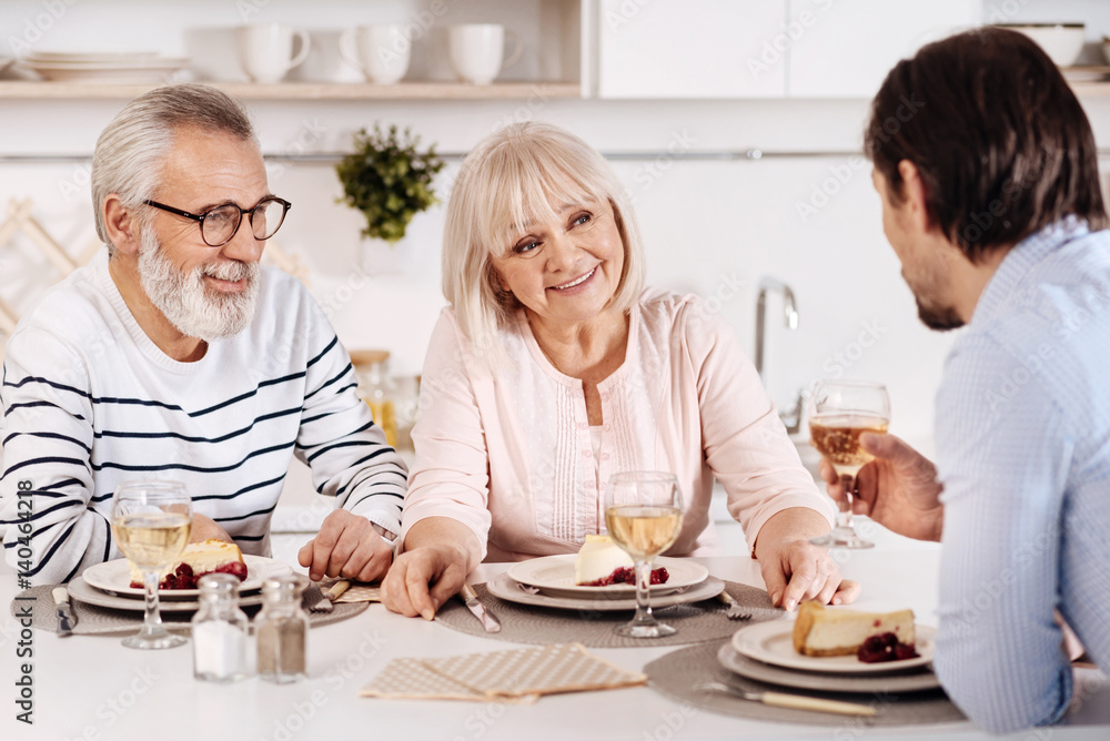Cheerful family sitting at the dinner table in the kitchen Cheerful family sitting at the dinner table in the kitchen