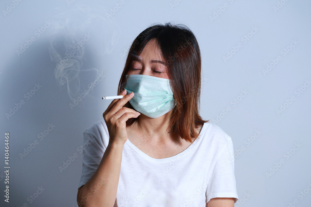 Stop smoking concept young woman smoking cigarette with
protective mask
Stop smoking concept young woman smoking cigarette with
protective mask