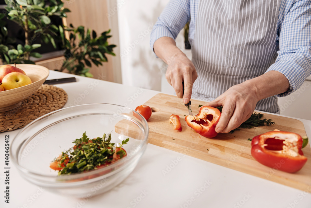 Professional cook cutting pepper for dinner in the kitchen