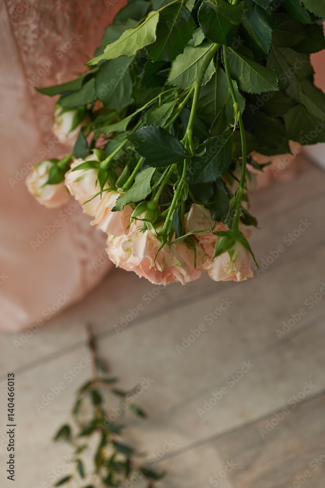 Bouquet of delicate pink spray roses on a background of pink lace dress Bouquet of delicate pink spray roses on a background of pink lace dress