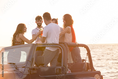 Five young people having fun in convertible car at the beach at sunset. © FS-Stock