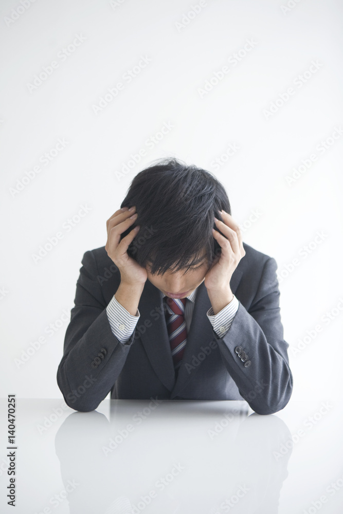 Young businessman with head in hands Young businessman with head in hands
