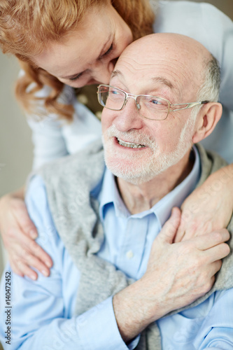 Happy life: Portrait of smiling elderly man and woman embracing caringly and cuddling looking carefree 