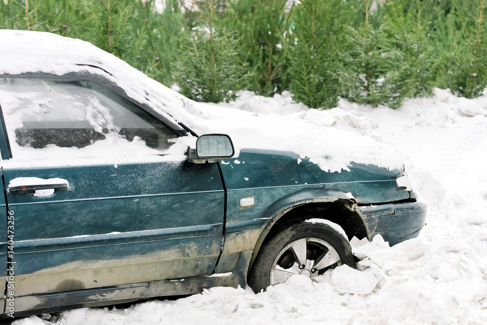 Old dirty parked car covered with snow