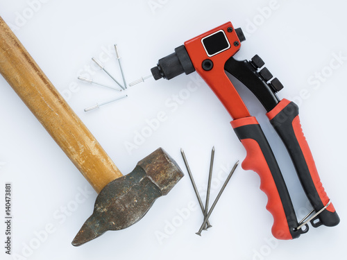 Old hammer and nails against new Rivet Gun and Rivets photo