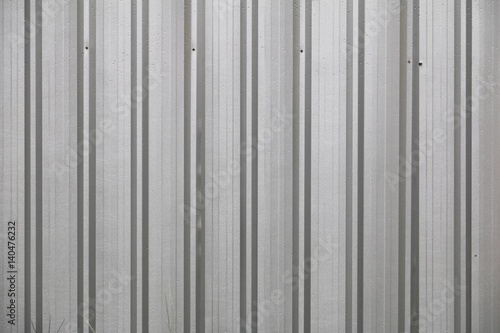 Corrugated metal wall and drop water , detail of lined shiny steel